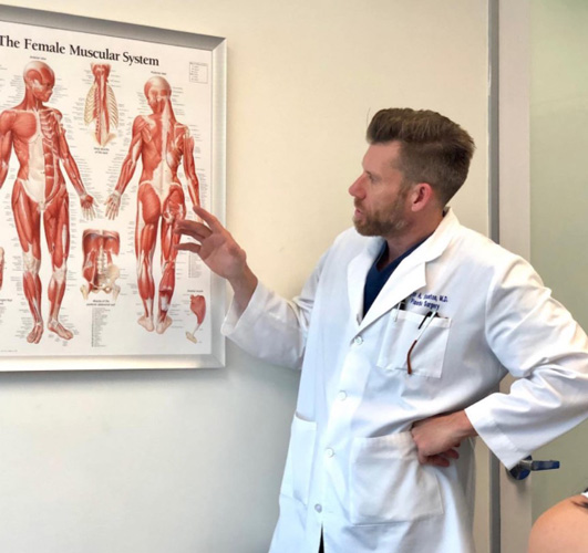 Dr. Ryan Stanton explaining female muscular system to patient